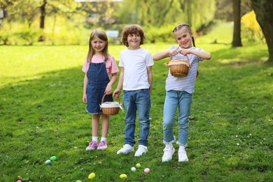 Photo of Easter celebration. Cute little children with wicker baskets and painted eggs outdoors