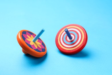 Photo of Two colorful spinning tops on light blue background