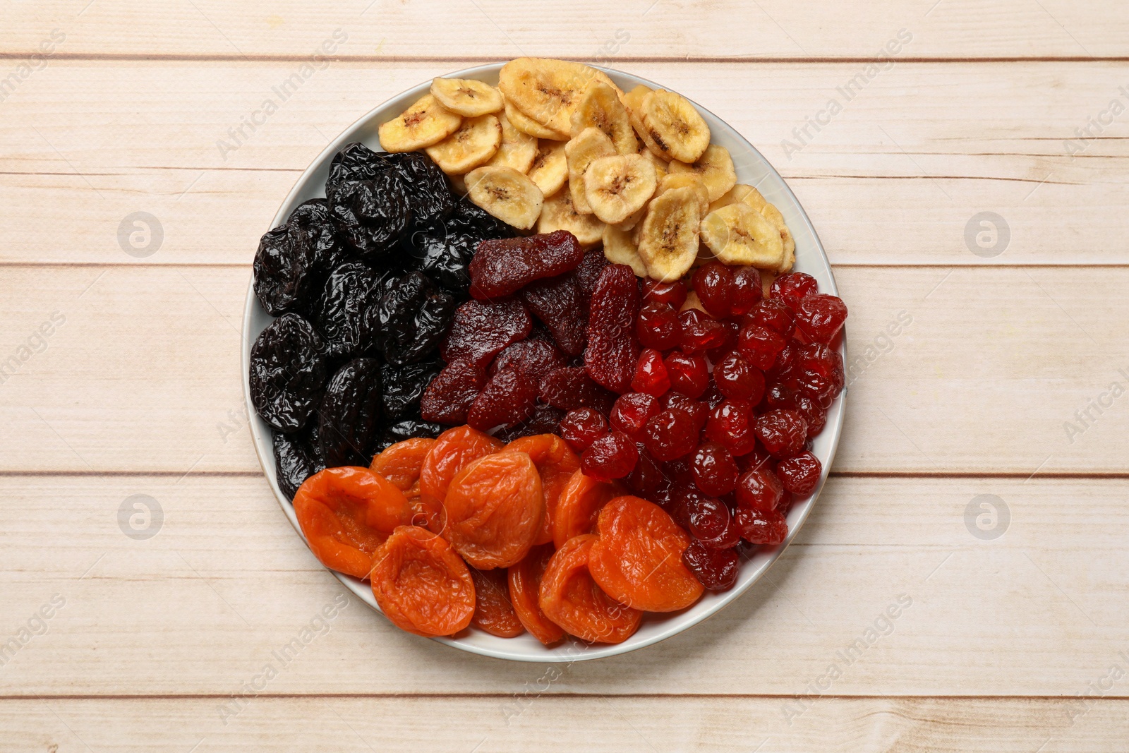 Photo of Delicious dried fruits on white wooden table, top view