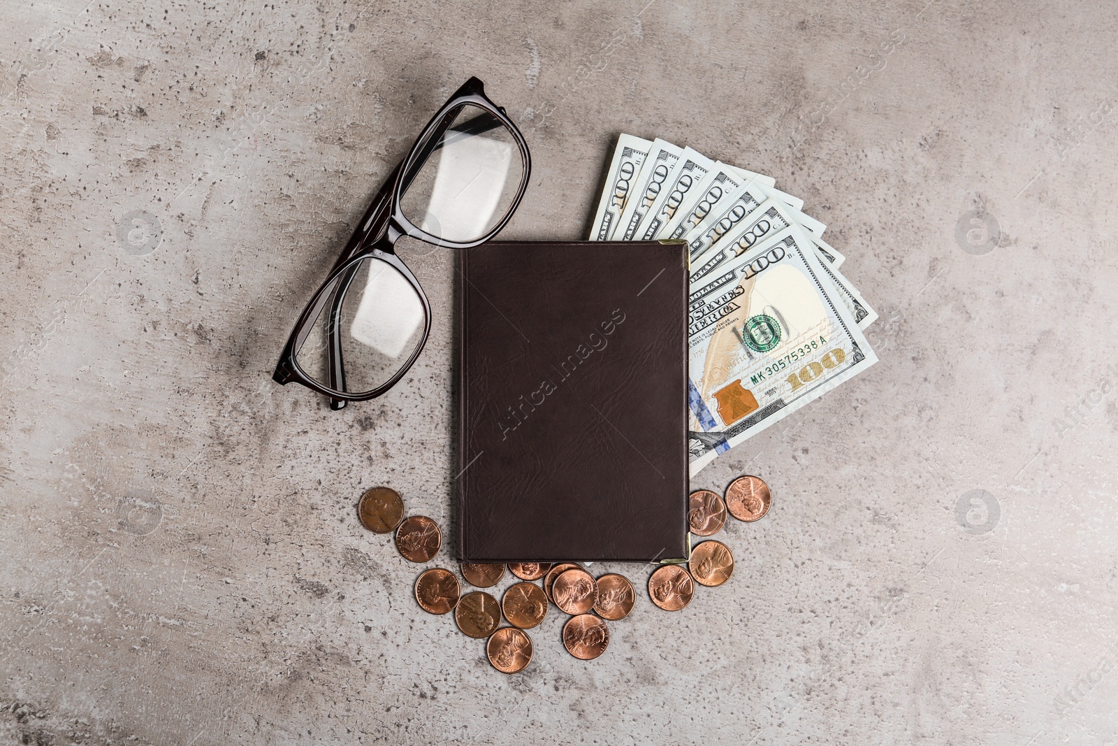 Photo of Pension certificate with American money and glasses on grey stone table, flat lay