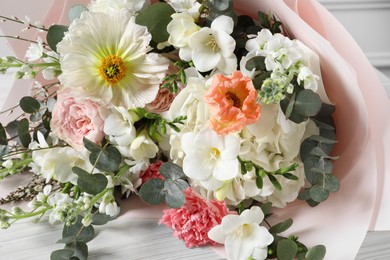 Photo of Bouquet of beautiful flowers on white wooden table, closeup