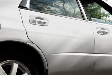 Photo of Modern gray car with scratch outdoors, closeup