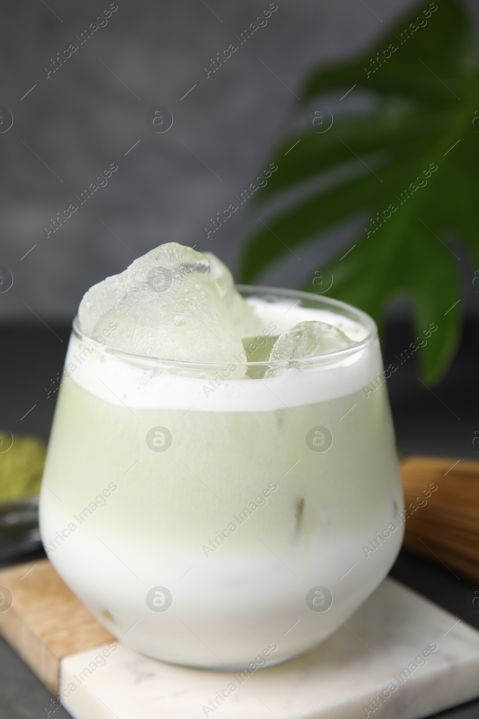 Photo of Glass of tasty iced matcha latte on table