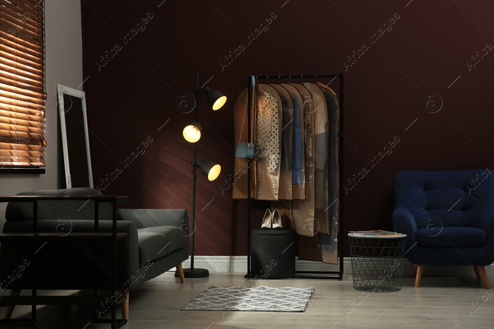 Photo of Garment bags with clothes hanging on rack in room