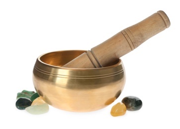 Golden singing bowl with mallet and healing stones on white background