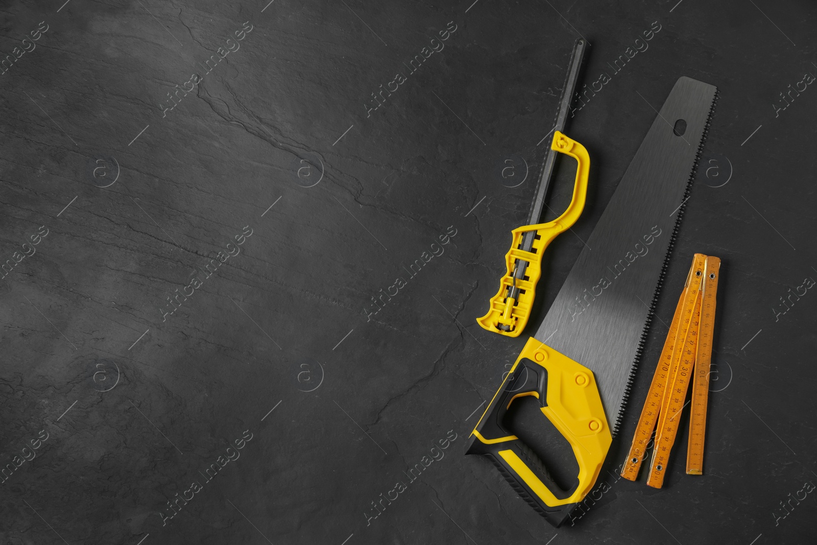 Photo of Modern carpenter's tools on black background, flat lay. Space for text
