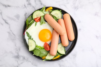 Photo of Delicious breakfast with boiled sausages and fried egg on white marble table, top view