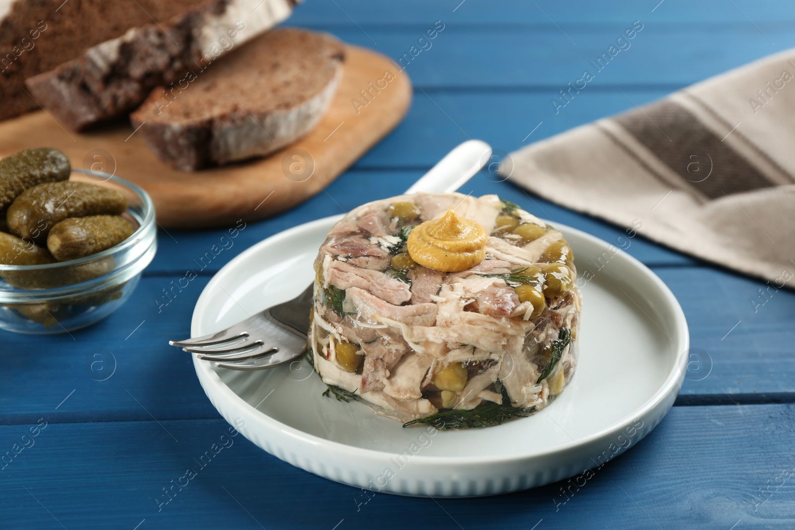 Photo of Delicious aspic with meat on blue wooden table