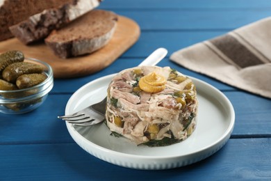 Photo of Delicious aspic with meat on blue wooden table