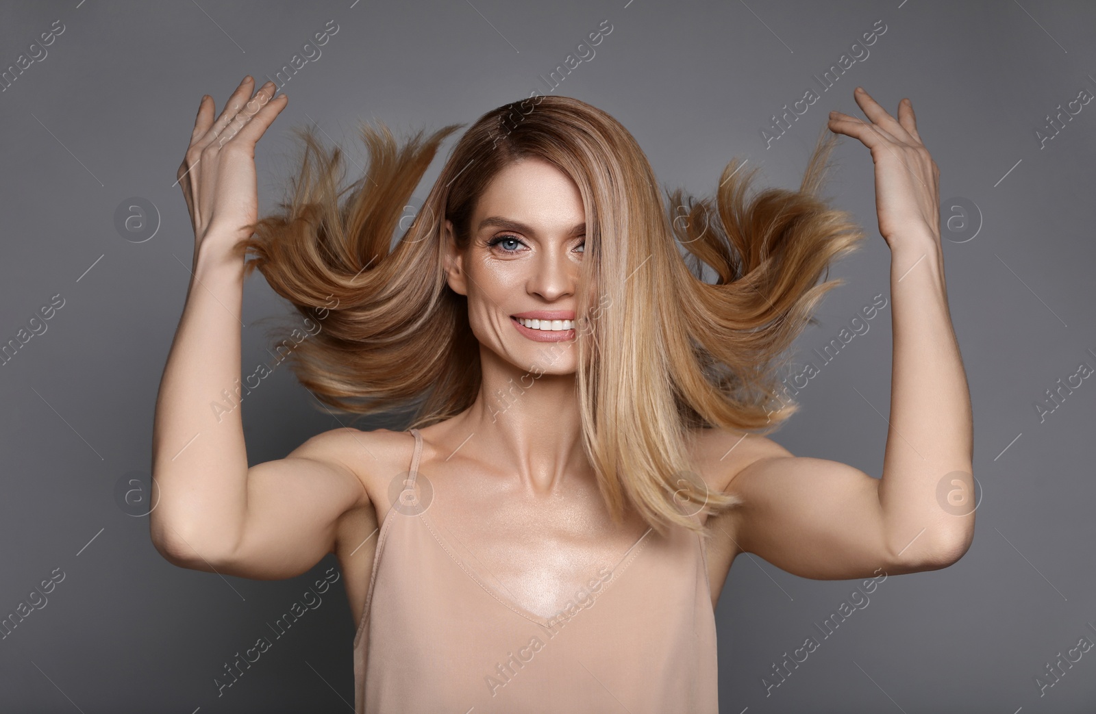 Image of Portrait of attractive woman with blonde hair on grey background