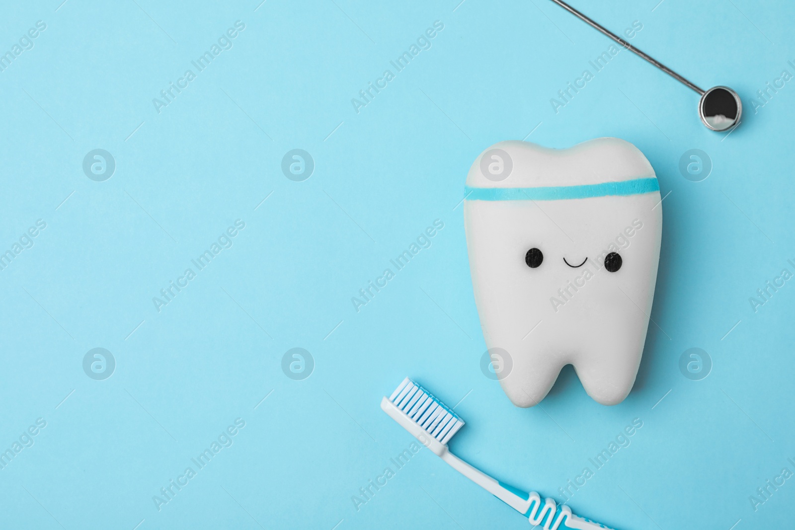 Photo of Flat lay composition with tooth, brush and mirror on color background, space for text. Professional dentist