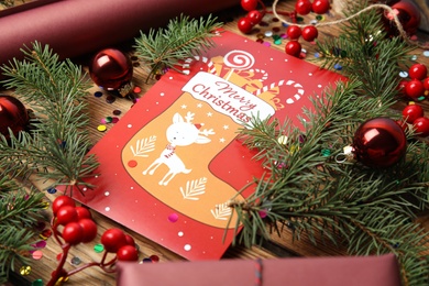 Christmas card and festive decor on wooden background, closeup