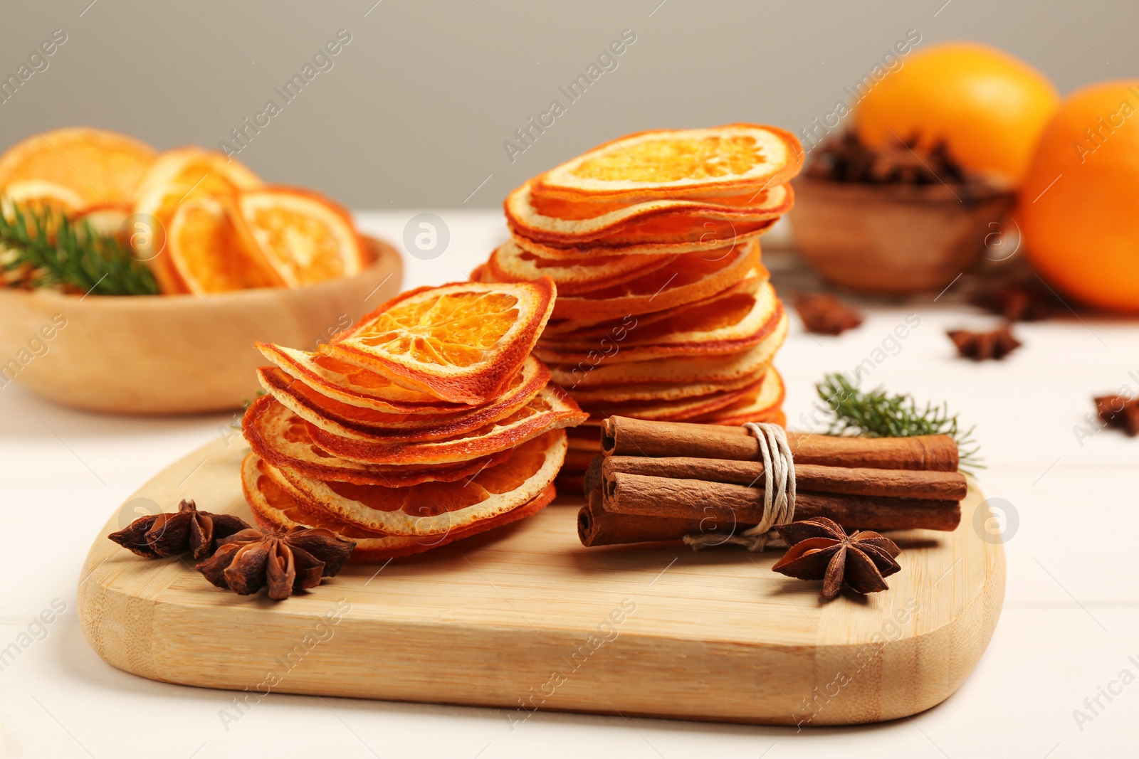 Photo of Dry orange slices, anise stars and cinnamon sticks on white table