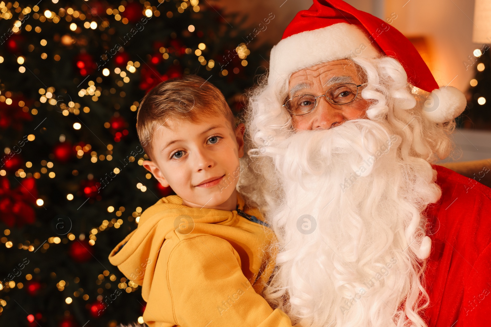 Photo of Merry Christmas. Santa Claus and little boy in room, space for text