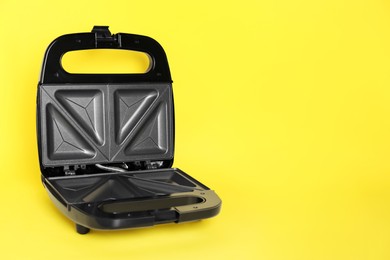 Open sandwich maker on yellow background. Space for text