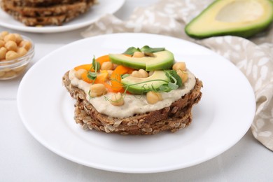 Photo of Tasty vegan sandwich with avocado, chickpeas and bell pepper on white table, closeup