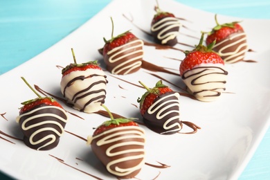 Photo of Plate with chocolate covered strawberries on table, closeup