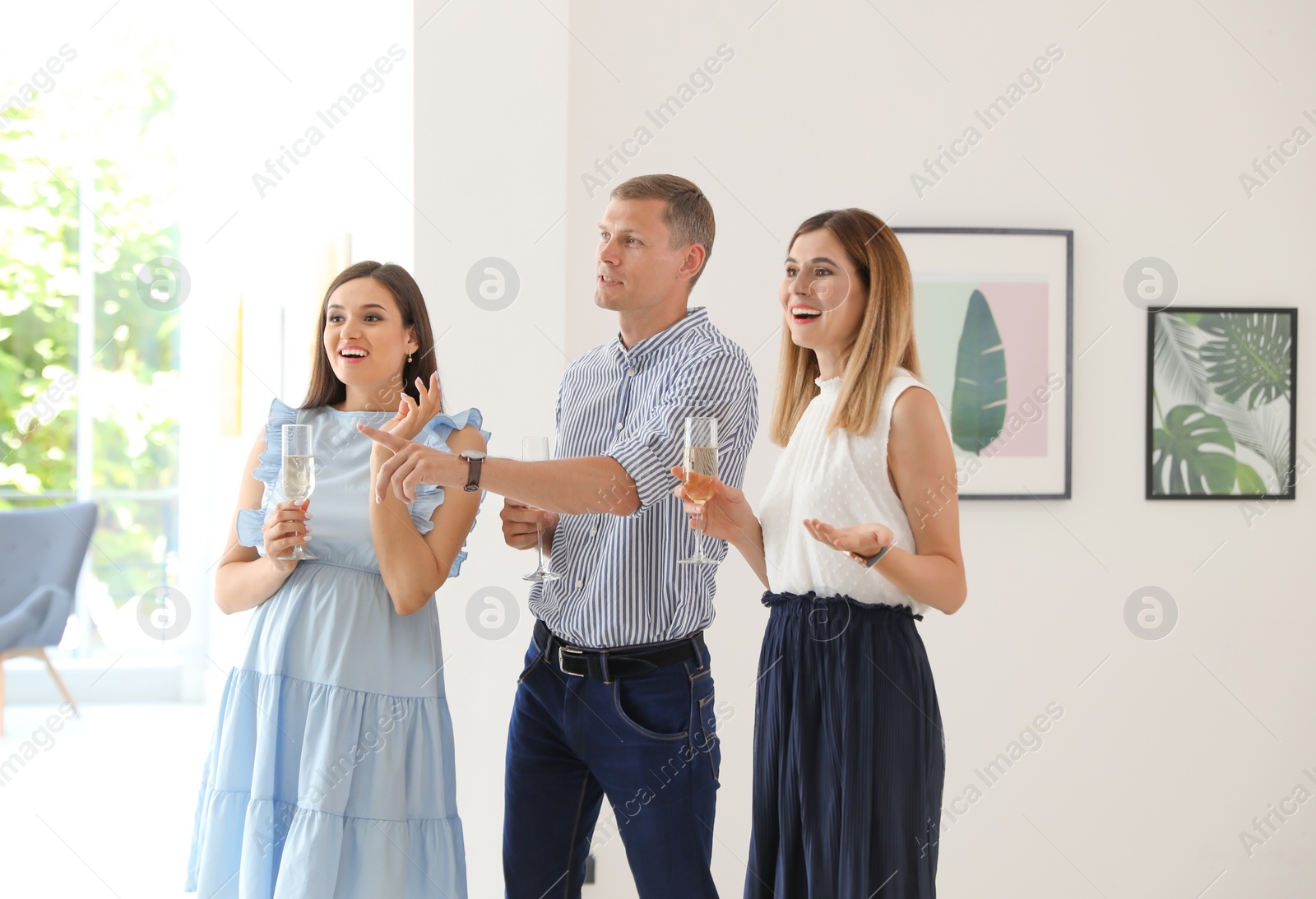 Photo of Group of people with glasses of champagne at exhibition in art gallery