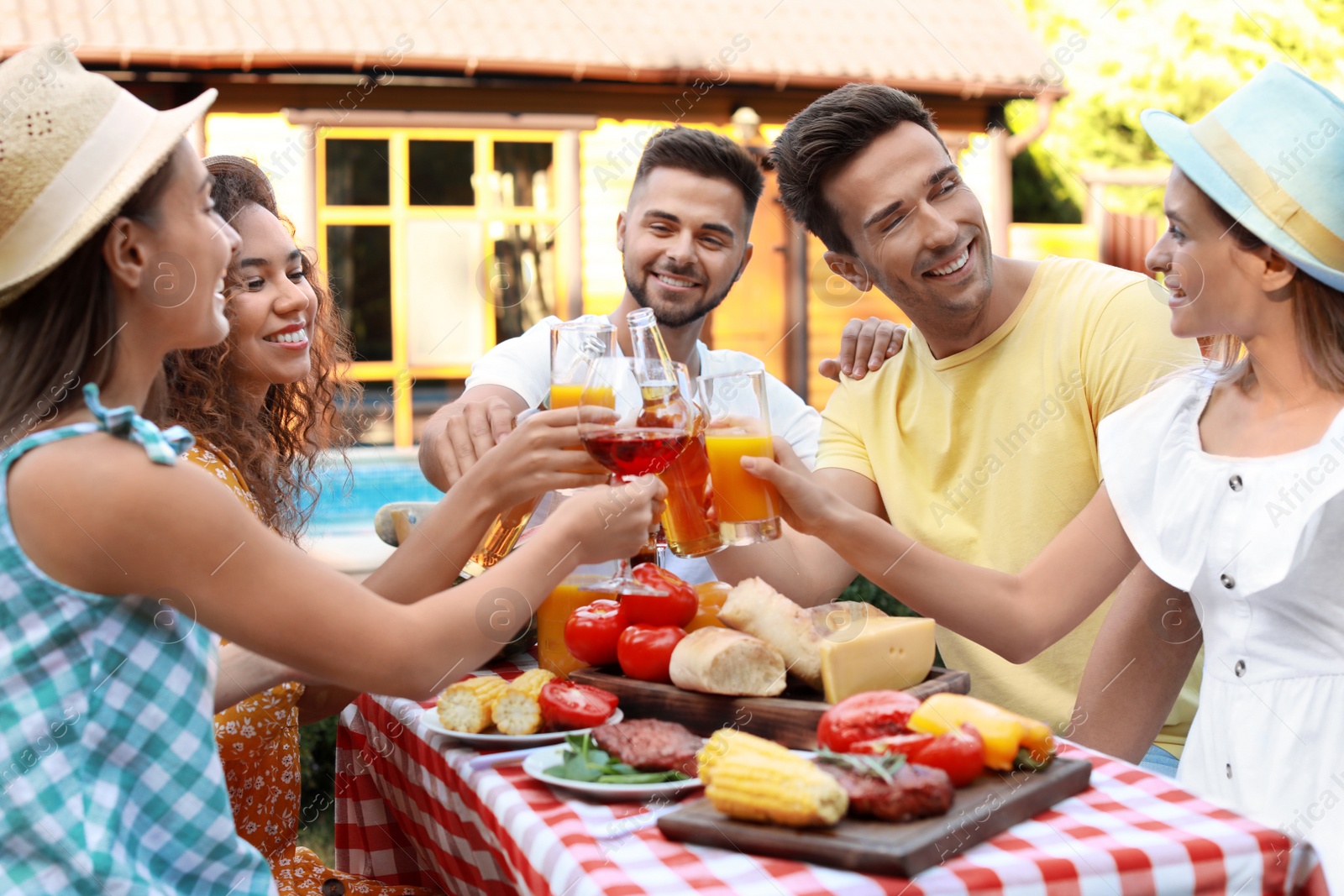 Photo of Happy friends with drinks having fun at barbecue party outdoors