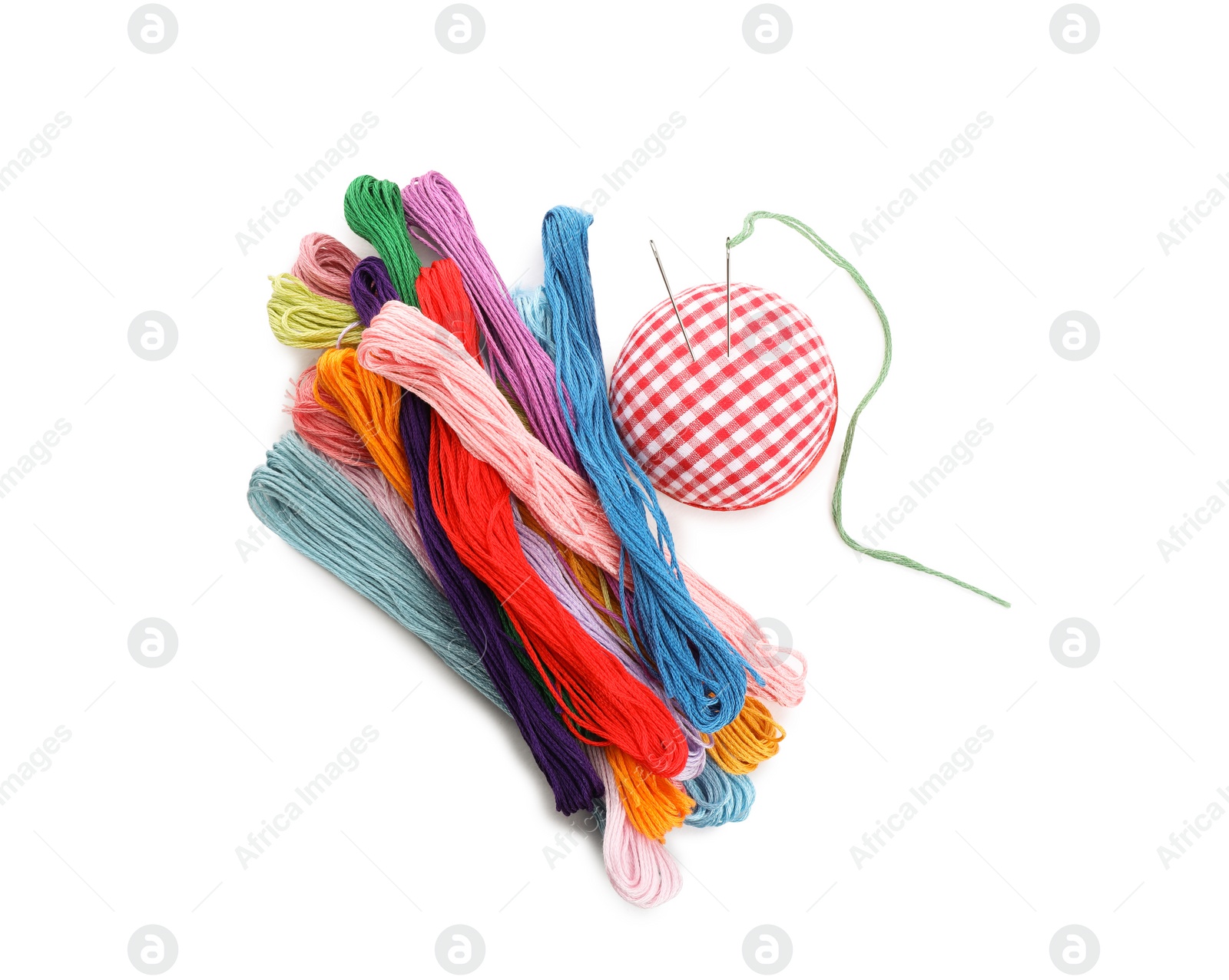 Photo of Colorful embroidery floss set and needle cushion on white background, top view