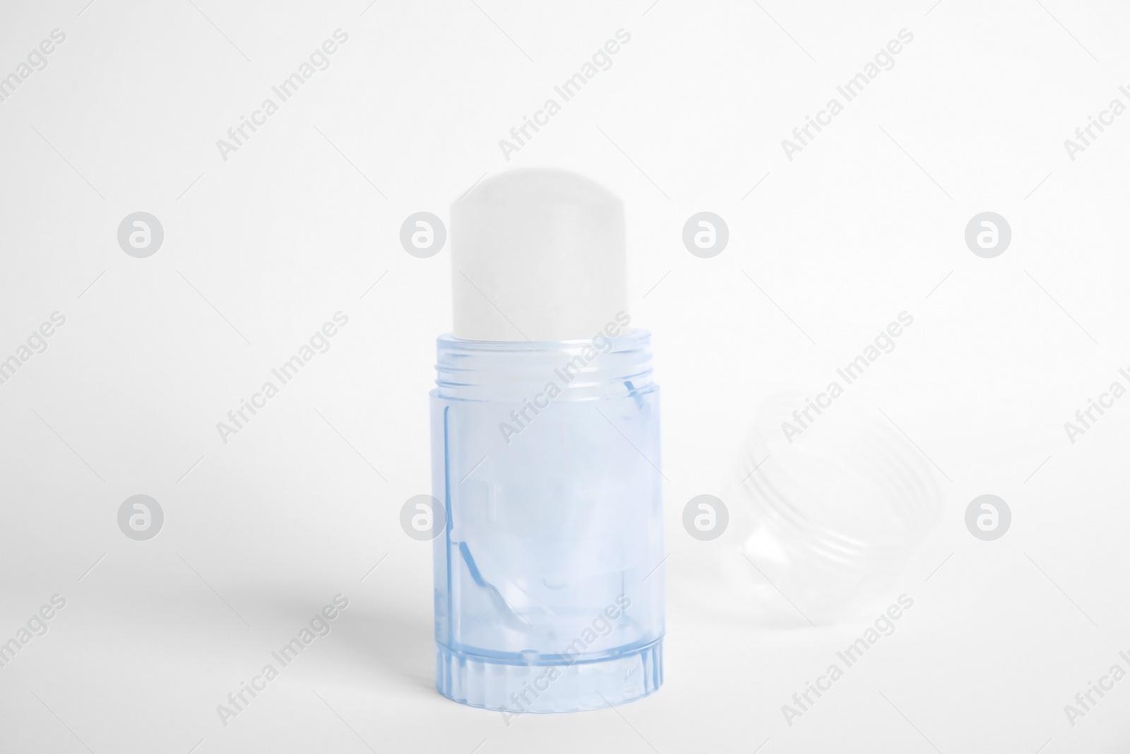 Photo of Natural crystal alum stick deodorant and cap on white background