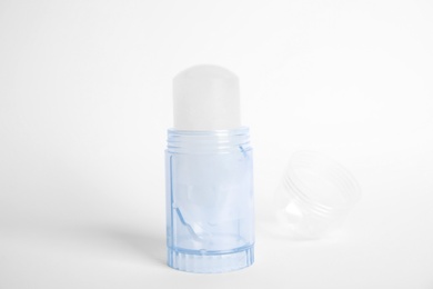 Photo of Natural crystal alum stick deodorant and cap on white background