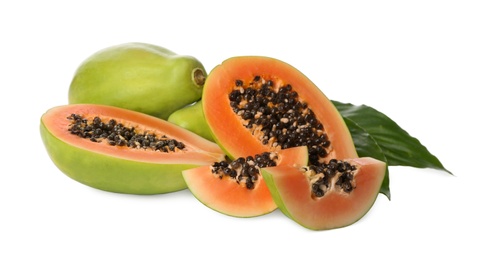 Fresh ripe papaya fruits with green leaves on white background