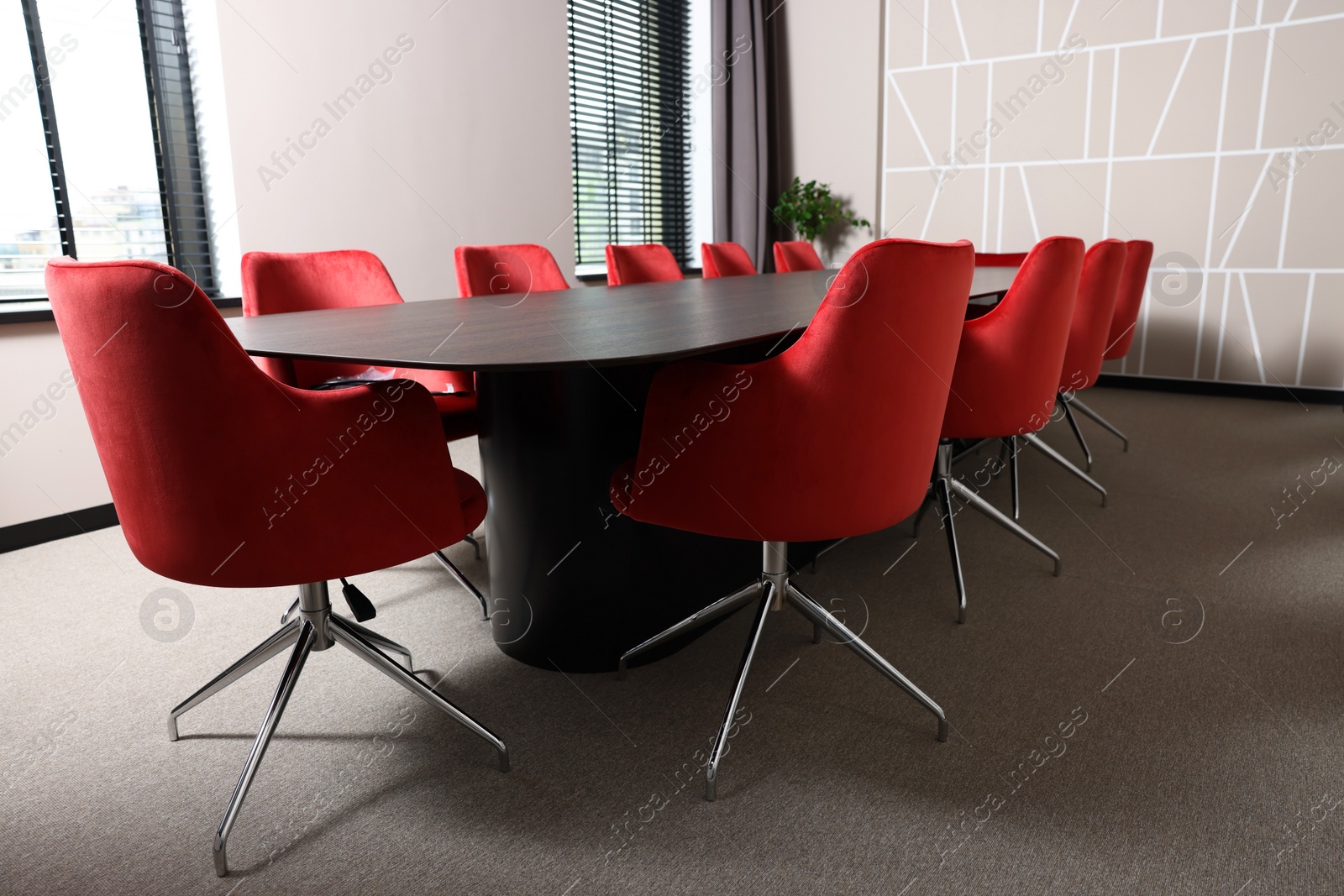 Photo of Empty conference room with stylish red office chairs and large wooden table