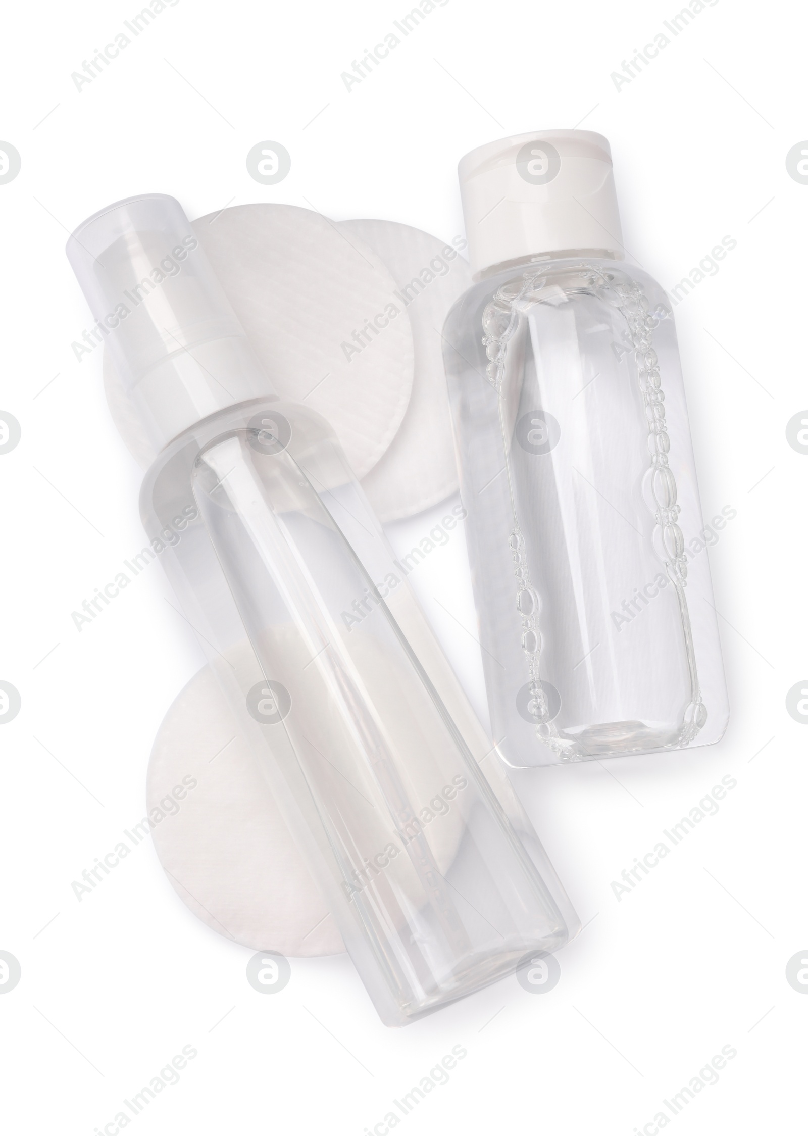 Photo of Bottles with micellar cleansing water and cotton pads on white background, top view