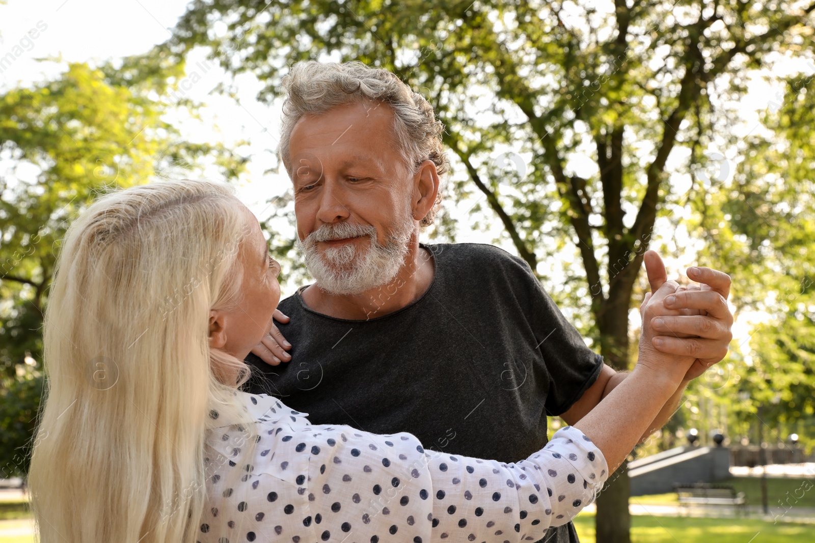 Photo of Lovely mature couple dancing together in park