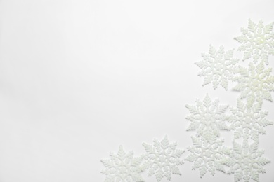 Beautiful decorative snowflakes on white background, flat lay. Space for text