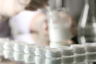 Photo of Small jars with cream in cosmetic laboratory