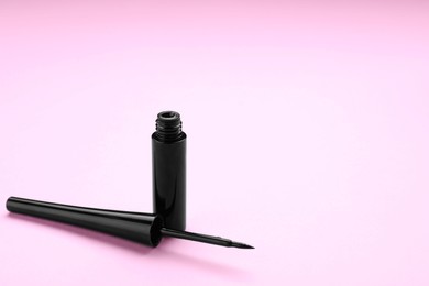 Photo of Black eyeliner on pink background, space for text. Makeup product