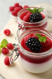 Photo of Delicious panna cotta with fruit coulis and fresh berries on table, closeup