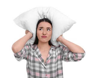 Photo of Tired young woman covering ears with pillow on white background. Insomnia problem