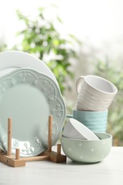 Beautiful ceramic dishware and cup on white marble table outdoors