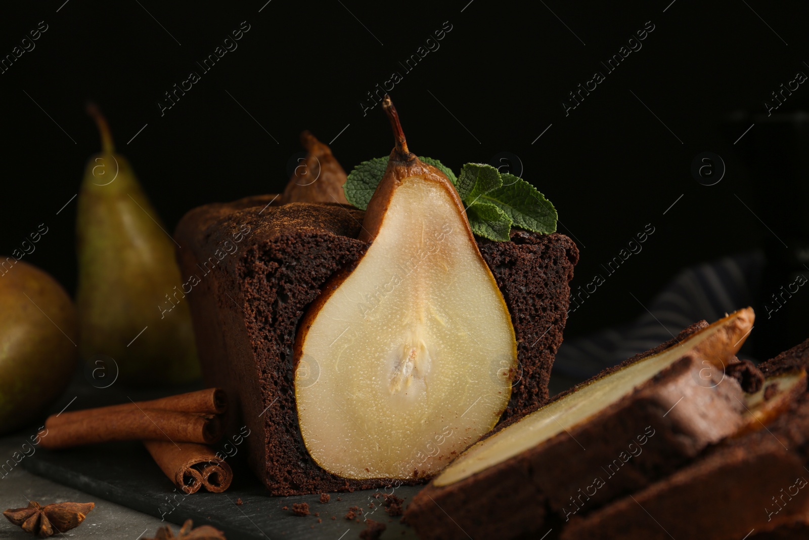 Photo of Tasty pear bread with spices and mint on grey table. Homemade cake