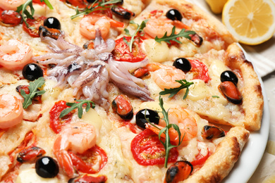 Photo of Tasty fresh pizza with seafood on table, closeup