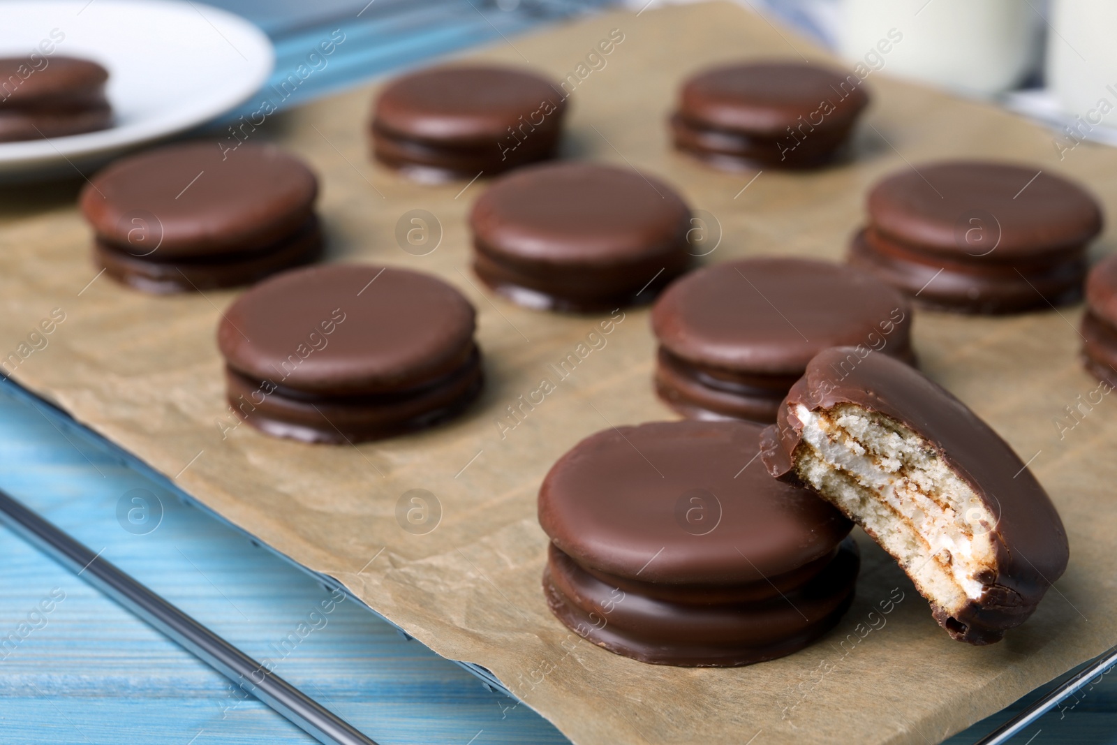 Photo of Tasty choco pies on light blue wooden table