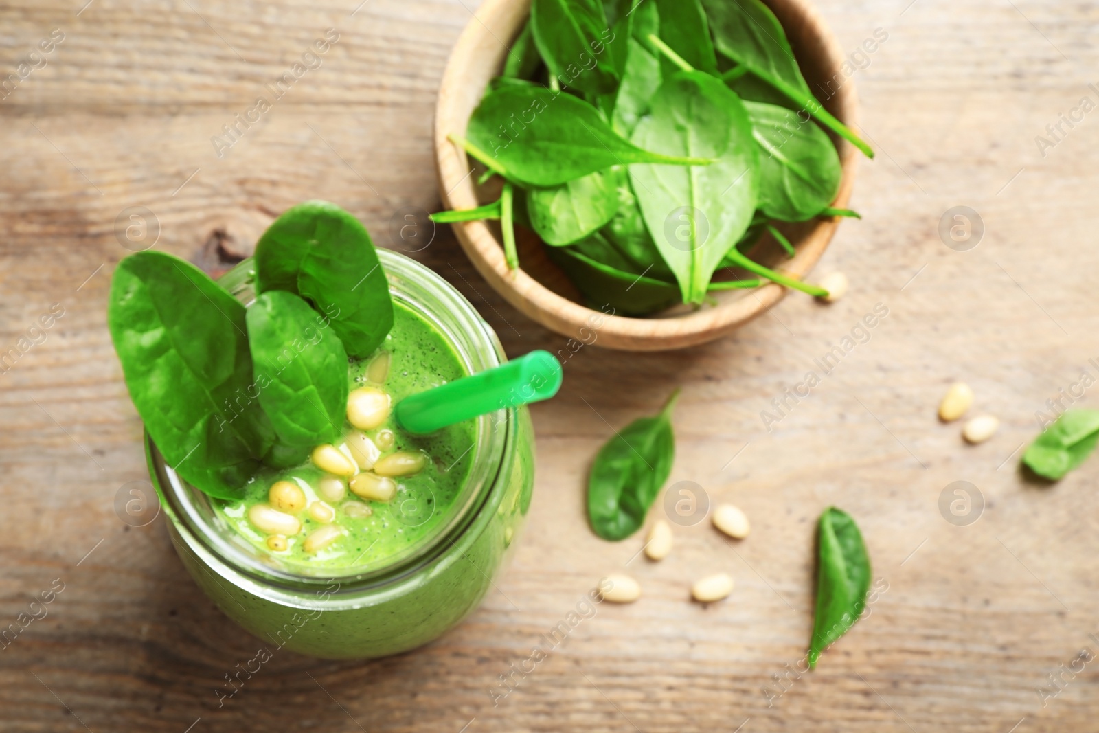 Photo of Flat lay composition with fresh green healthy spinach smoothie on wooden table