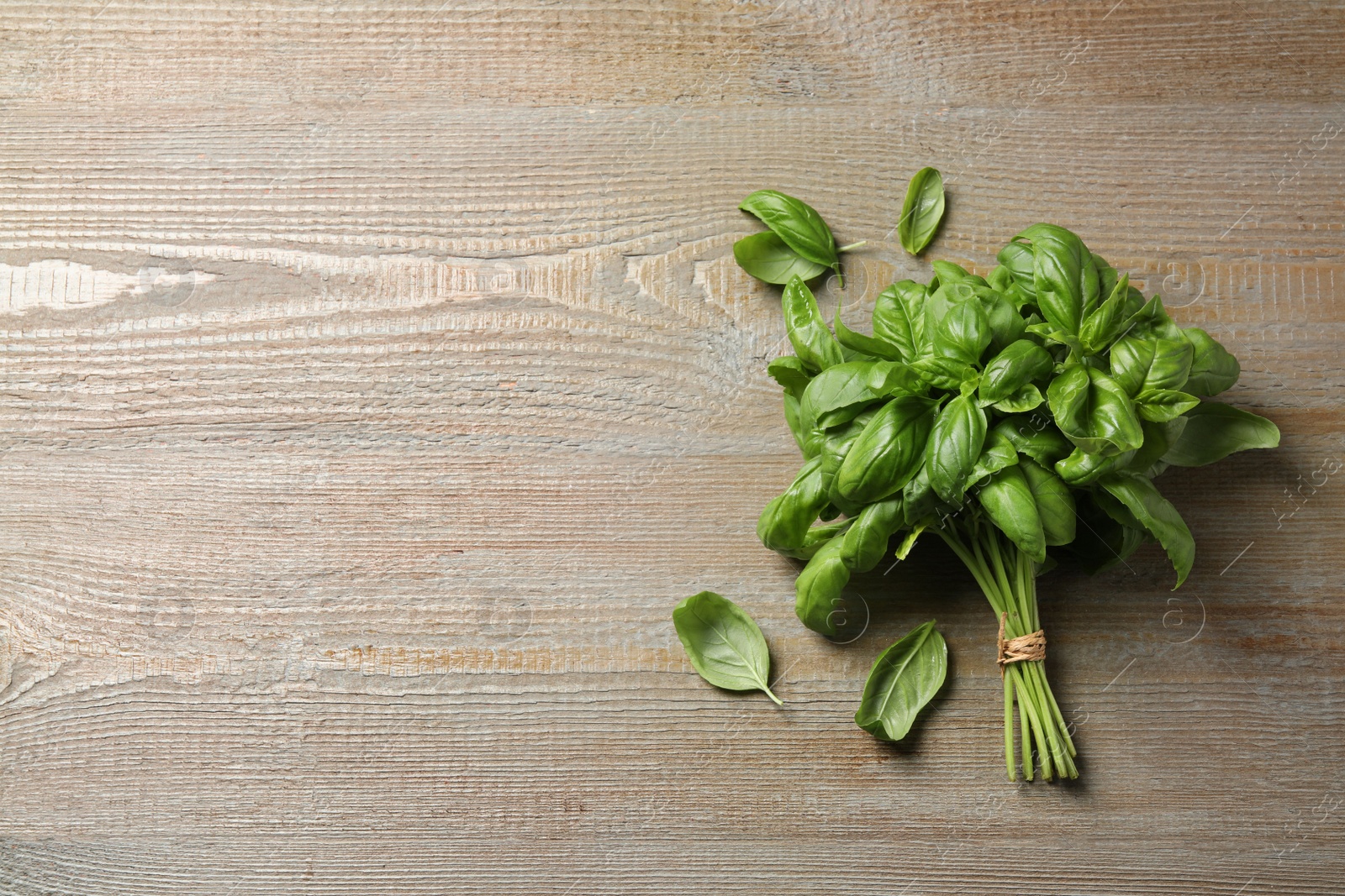 Photo of Fresh basil on wooden table, flat lay. Space for text