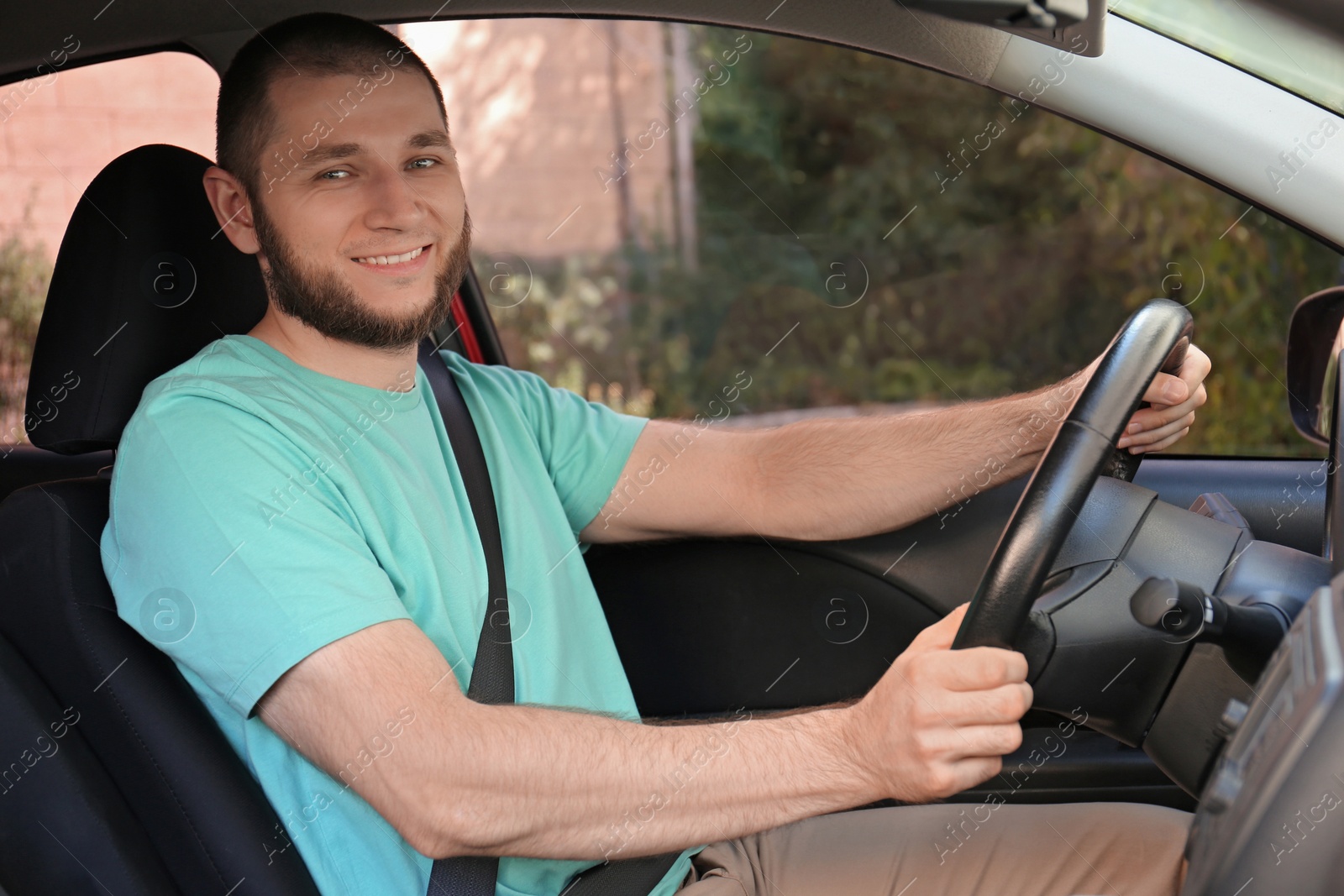 Photo of Man with fastened safety belt on driver's seat in car