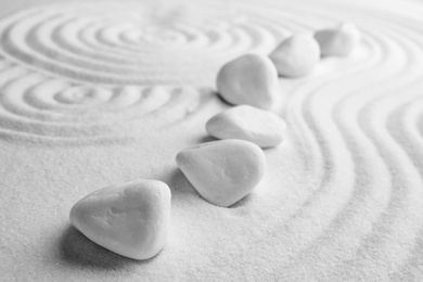 Photo of White stones on sand with pattern. Zen, meditation, harmony