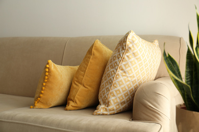 Image of Three pillows on sofa near wall in room. Interior design