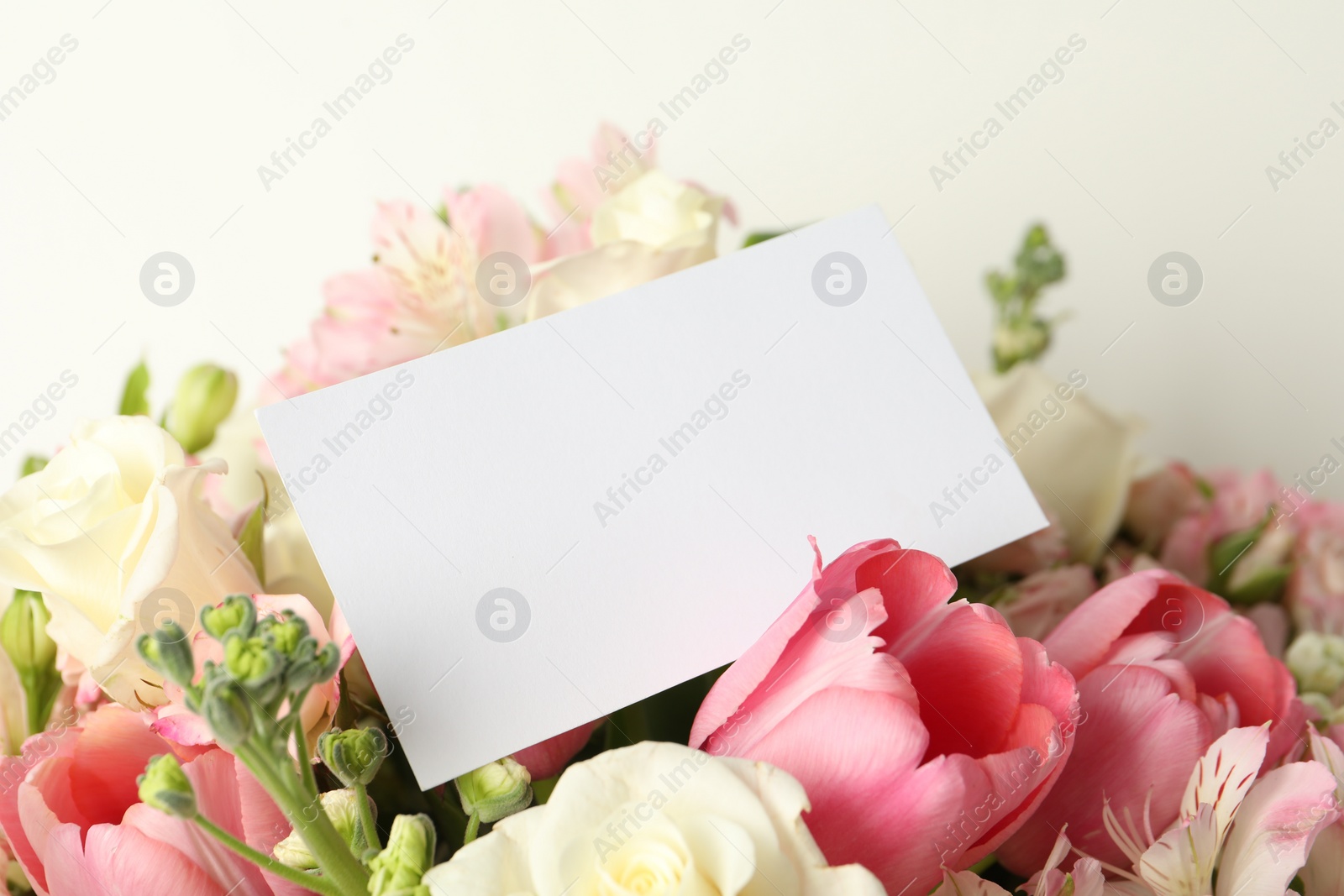 Photo of Happy Mother's Day. Beautiful flowers with blank card on light background, closeup