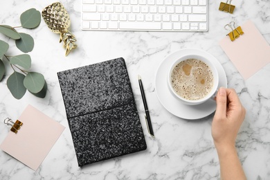 Photo of Blogger with coffee, notebook and keyboard on marble table, flat lay