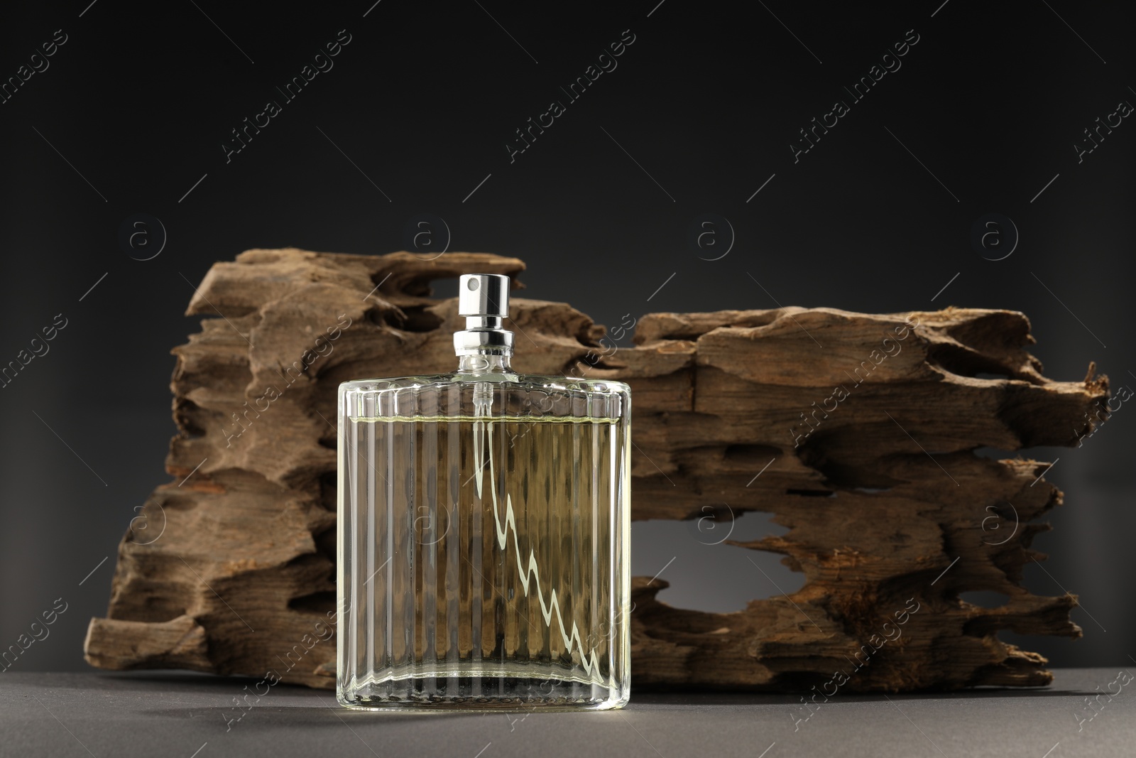 Photo of Luxury men`s perfume in bottle on grey table