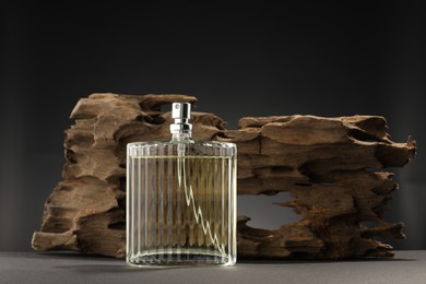 Photo of Luxury men`s perfume in bottle on grey table