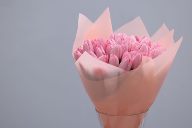 Photo of Bouquet of beautiful pink tulips on light grey background, space for text