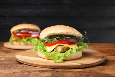 Photo of Delicious burgers with tofu and fresh vegetables on wooden table